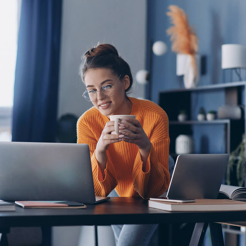 woman in orange sweater with cofee cup