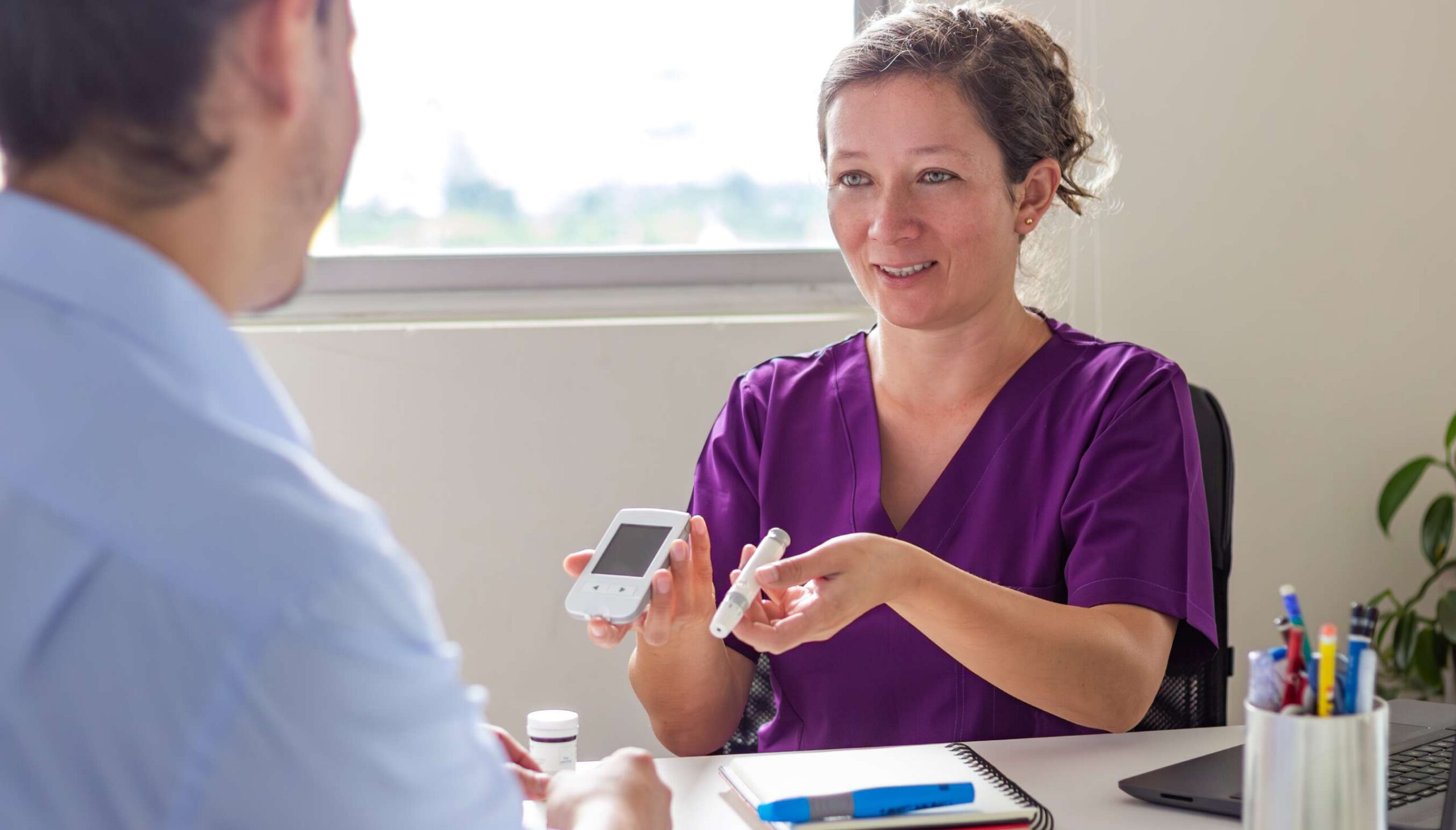 provider showing patient an autoinjector and digital support device
